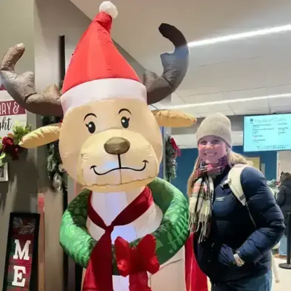 Image of 1A RA, Allison Hunt, standing next to an inflatable reindeer, smiling.